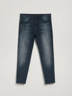 Ciemnoniebieskie jeansy carrot fit z mocnym efektem sprania