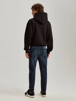 Ciemnoniebieskie jeansy carrot fit z mocnym efektem sprania