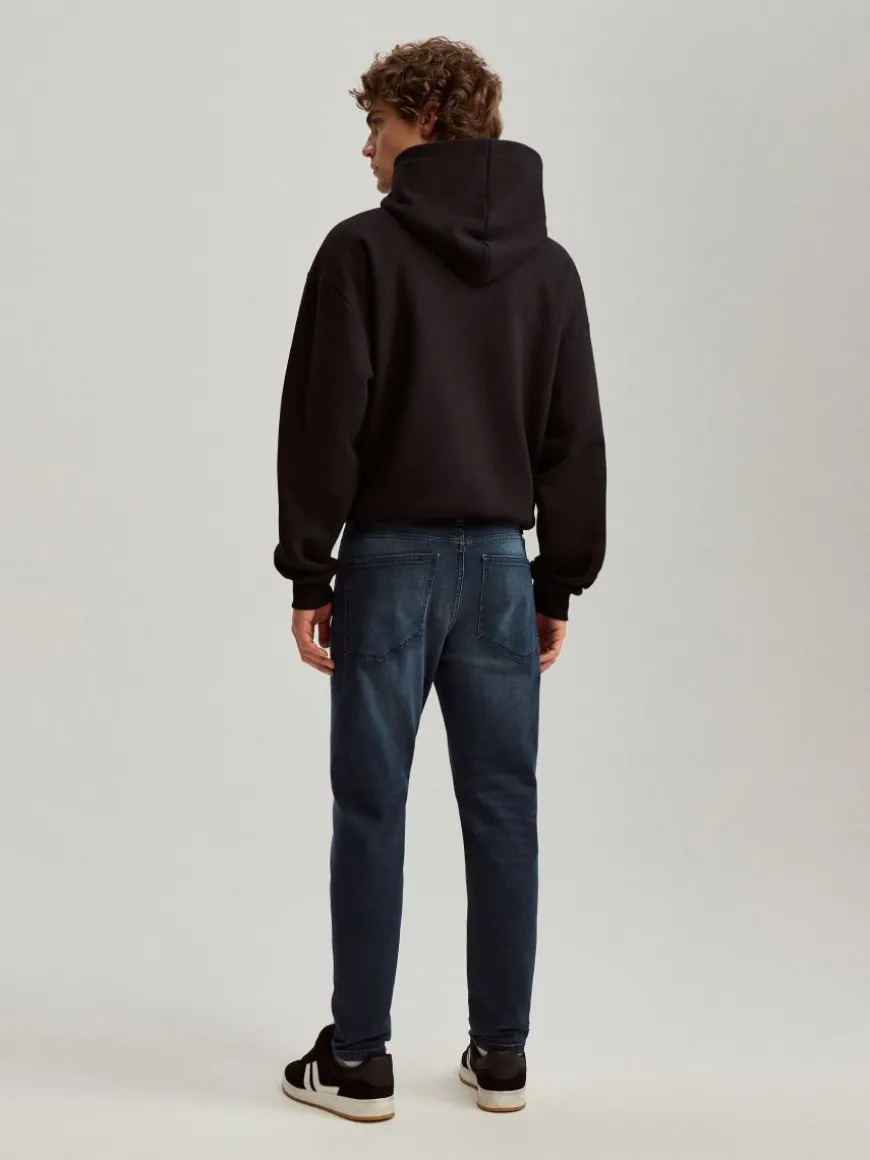 Ciemnoniebieskie jeansy carrot fit z mocnym efektem sprania