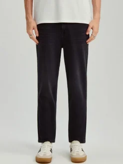 Czarne jeansy carrot fit z przetarciami