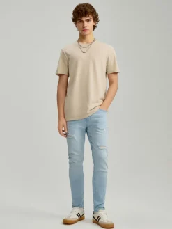 Jasnoniebieskie jeansy carrot fit z efektem sprania i przetarciami