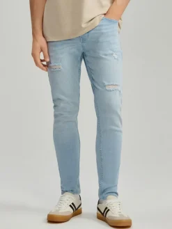 Jasnoniebieskie jeansy carrot fit z efektem sprania i przetarciami