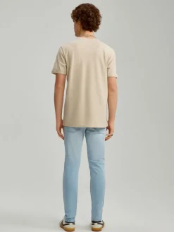 Jasnoniebieskie jeansy carrot fit z efektem sprania i przetarciami