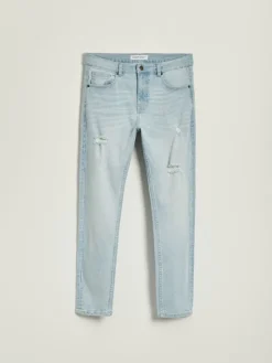 Jasnoniebieskie jeansy carrot fit z efektem sprania i przetarciami