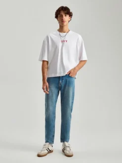 Niebieskie jeansy carrot fit z efektem sprania