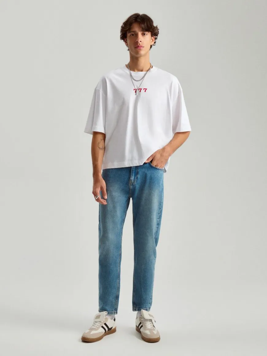 Niebieskie jeansy carrot fit z efektem sprania