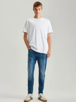 Niebieskie jeansy carrot fit z mocnym efektem sprania