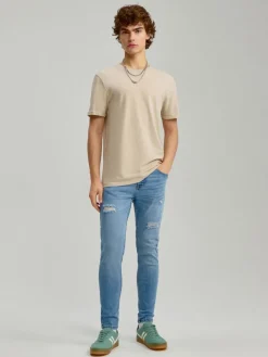 Niebieskie jeansy carrot fit z efektem sprania i przetarciami