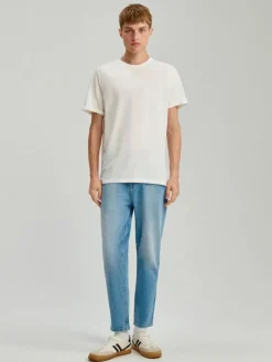Niebieskie jeansy carrot fit z przetarciami