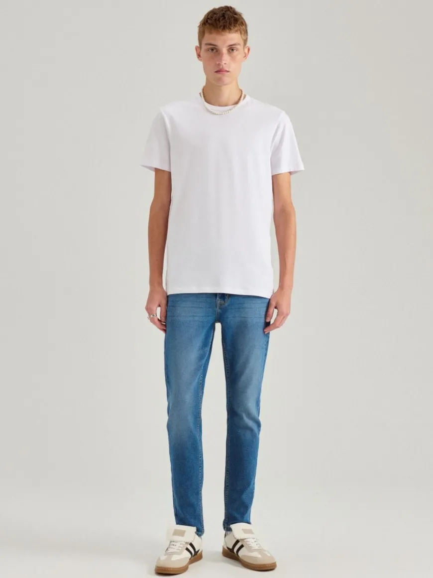 Niebieskie jeansy slim fit z przetarciami
