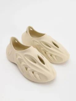 Zabudowane beżowe klapki o designie sneakersów